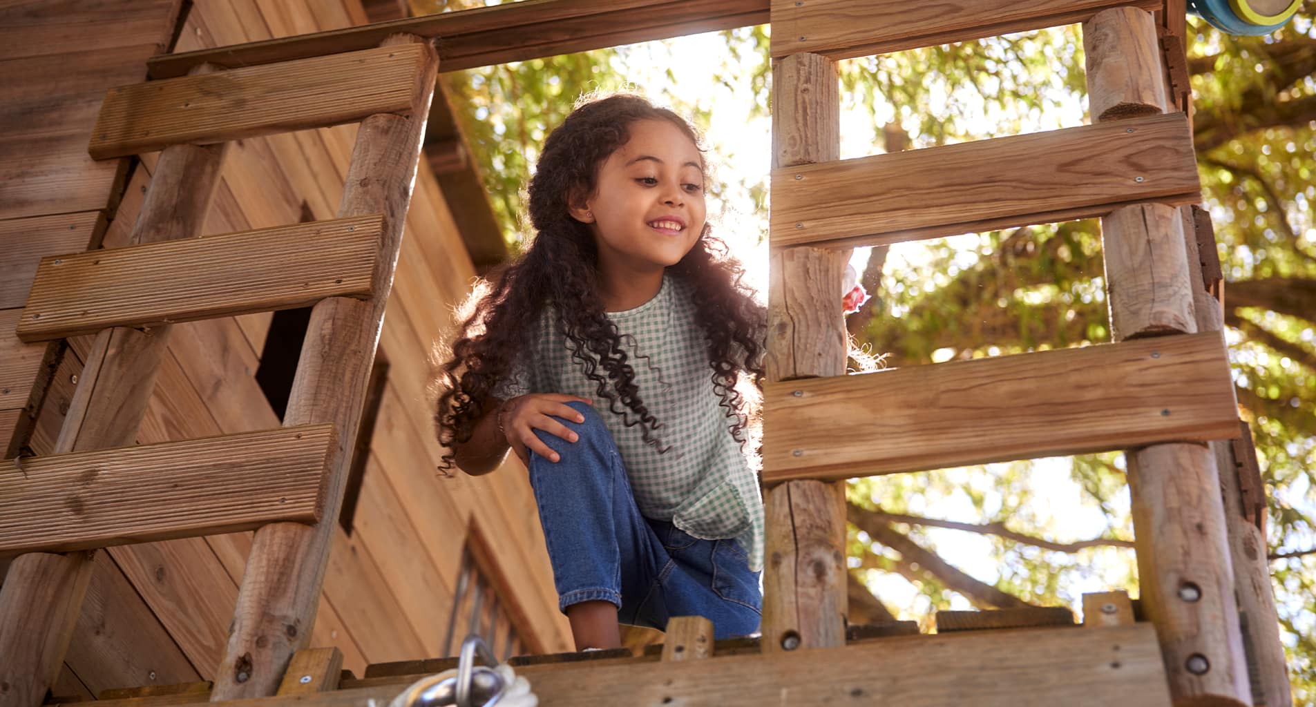 little girl playing in tree house