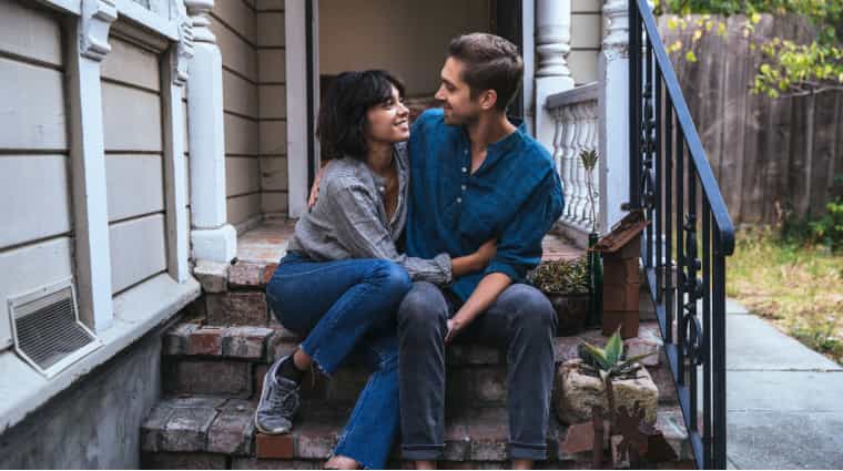 couple sitting on steps discussing mortgage approval