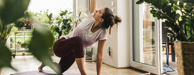 woman doing yoga in sunny room