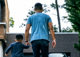 father and son holding hands in new backyard