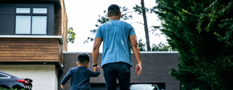 father and son holding hands in new backyard