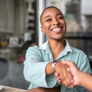 woman shaking hands with a man while sitting at a table