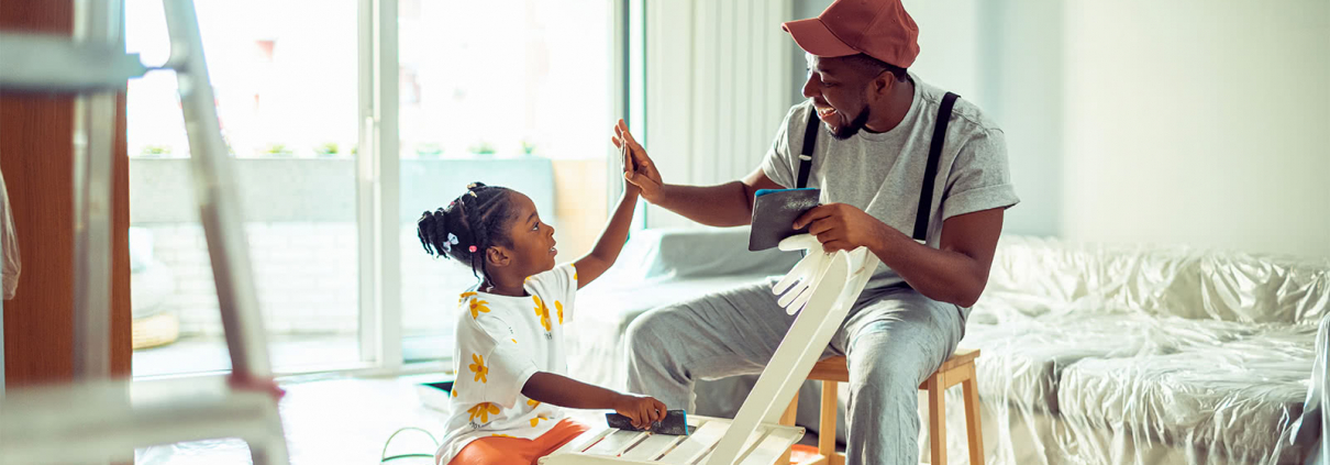 father and daughter sitting inside a home