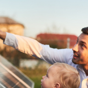 A man, woman, and child looking up at a set of solar panel
