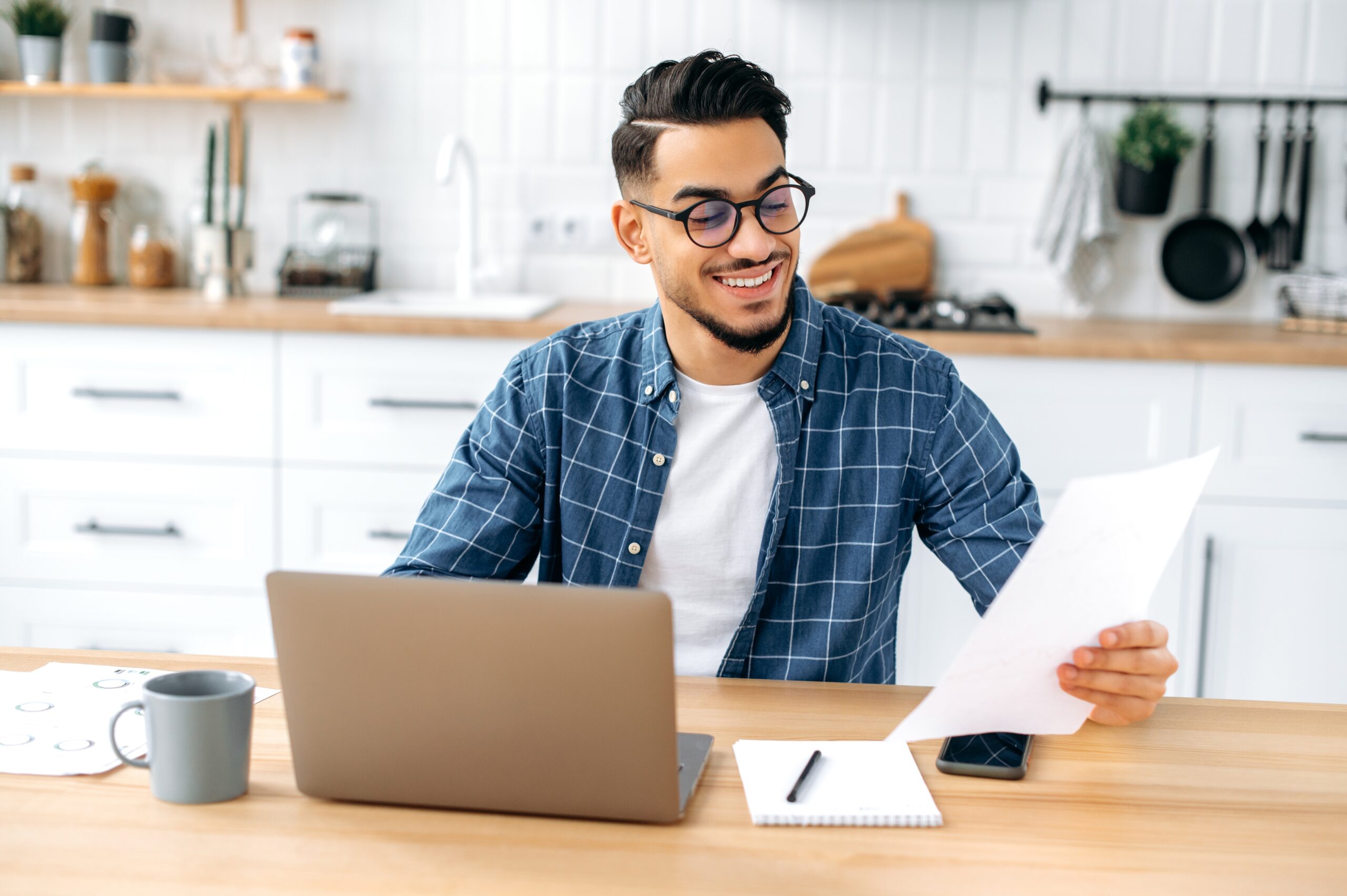 happy man paying mortgage bill in his living room