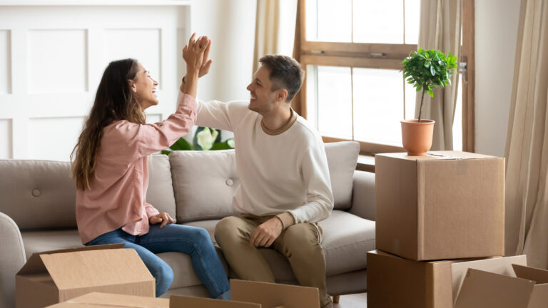 young couple celebrating their first-time home buying experience on move-in day