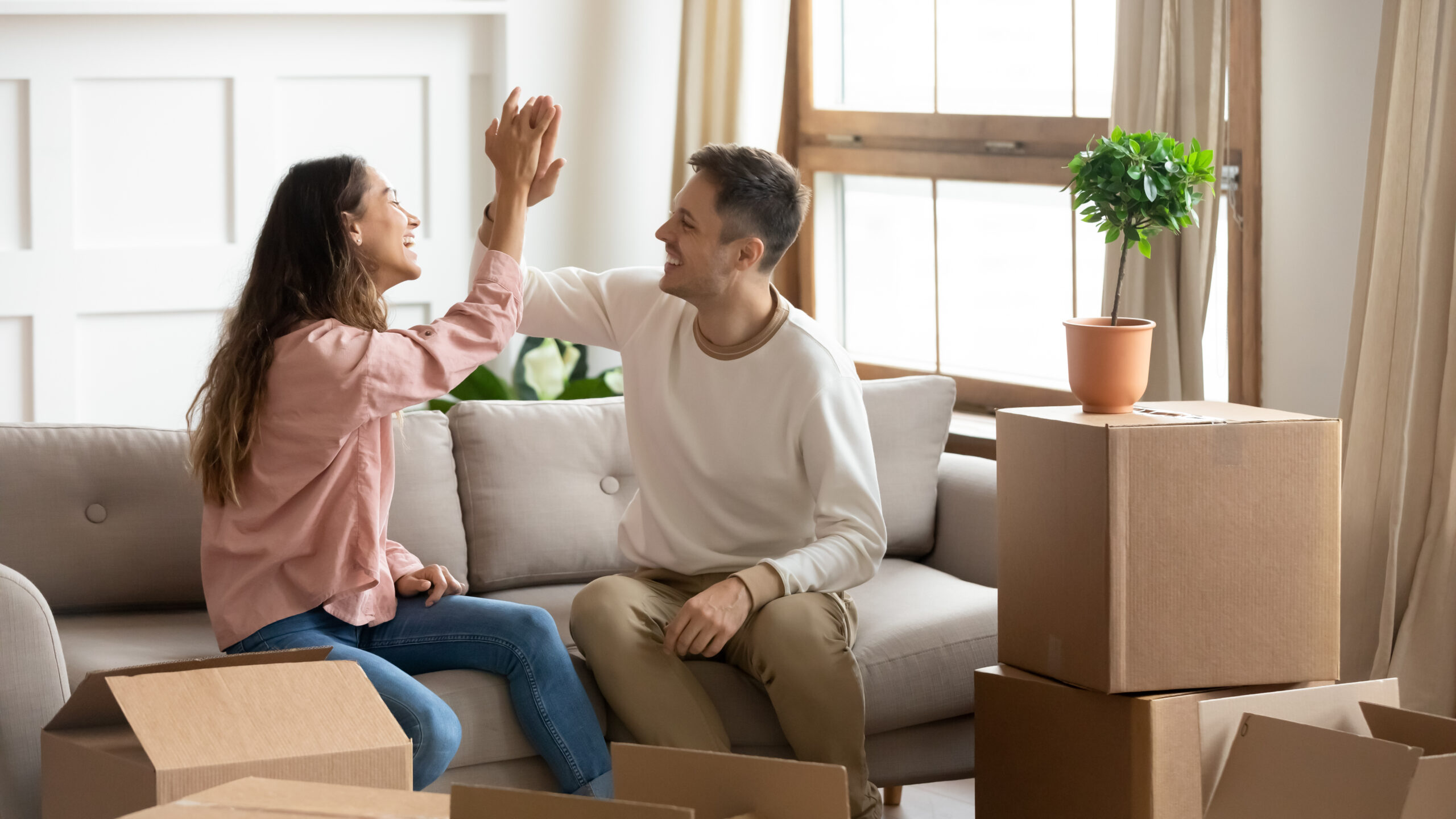 young couple celebrating their first-time home buying experience on move-in day