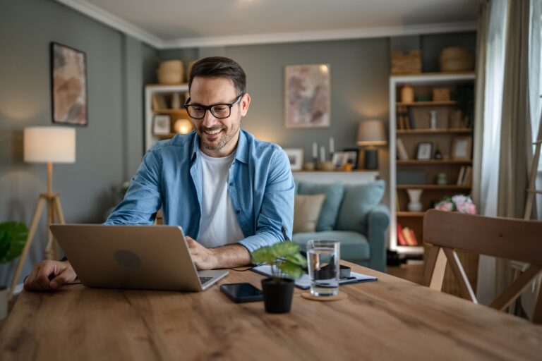 man at home on laptop researching inflation and mortgage rates
