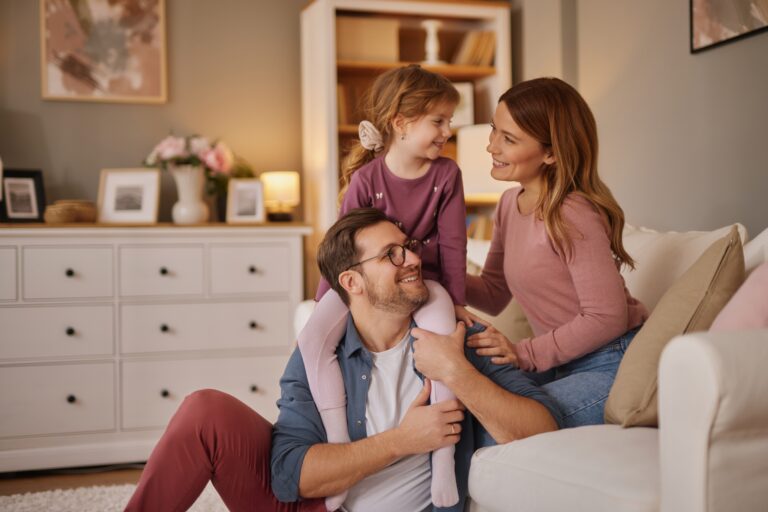 mom, dad, and young daughter play in child's room