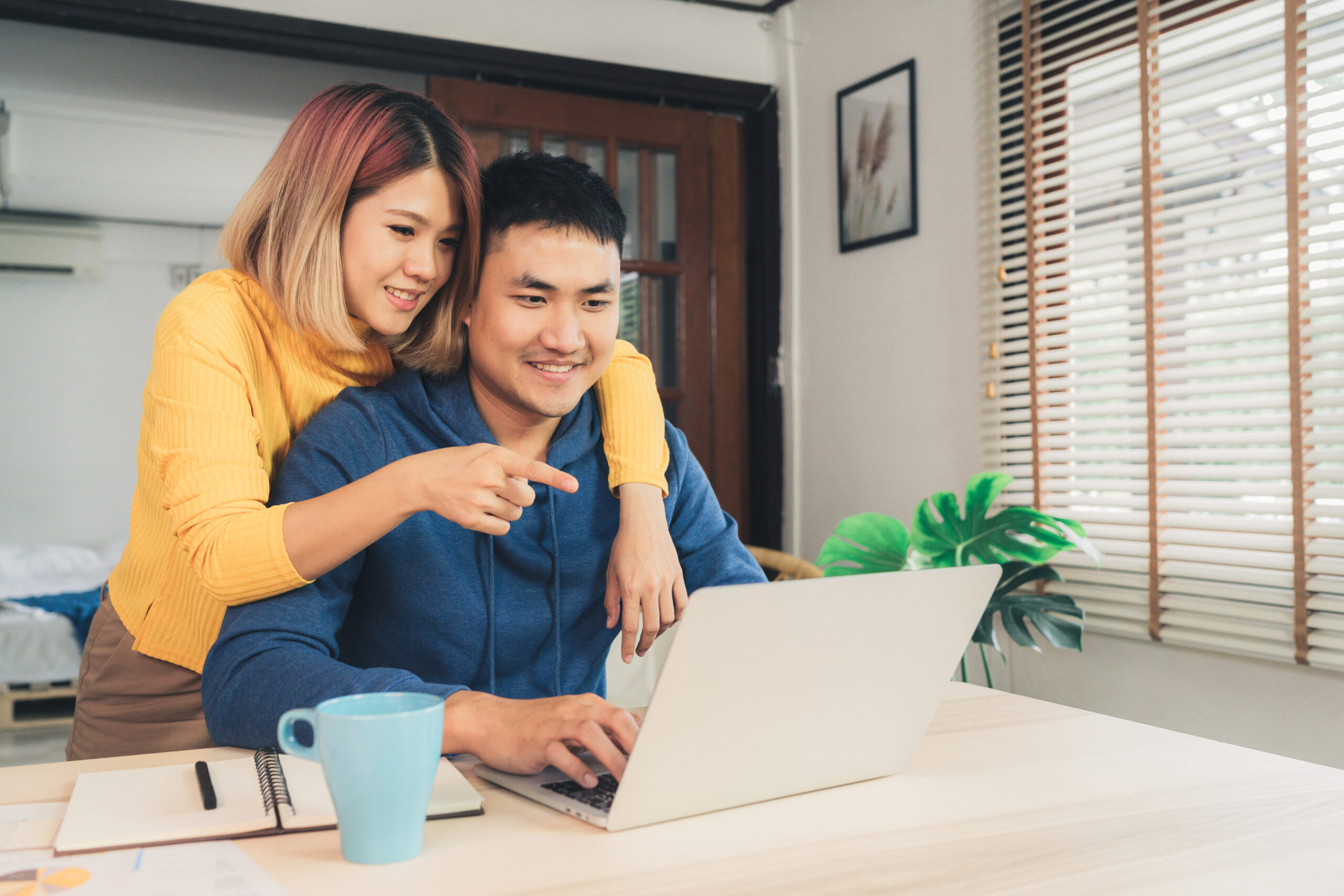 young couple on computer paying bills and checking credit score